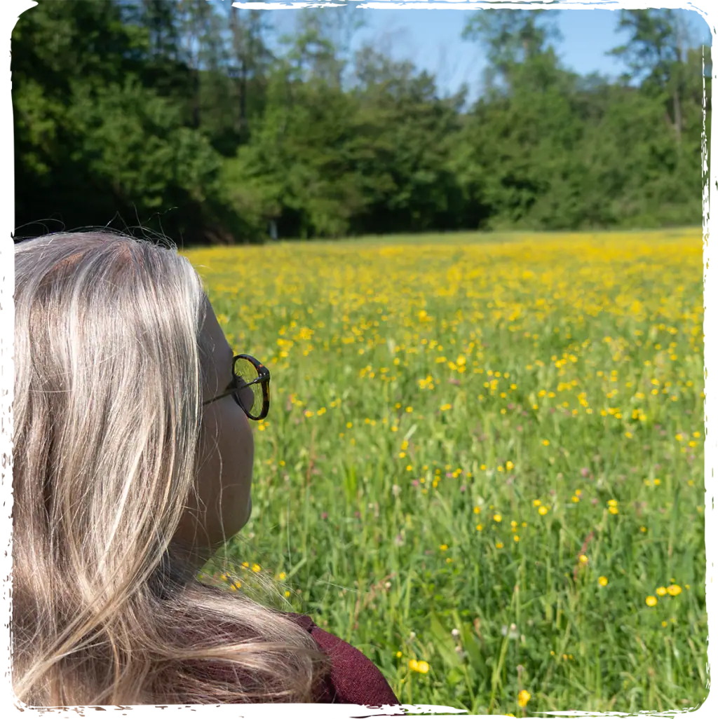Raphaela blickt über eine Blumenwiese für Fernreiki und Lebensenergie