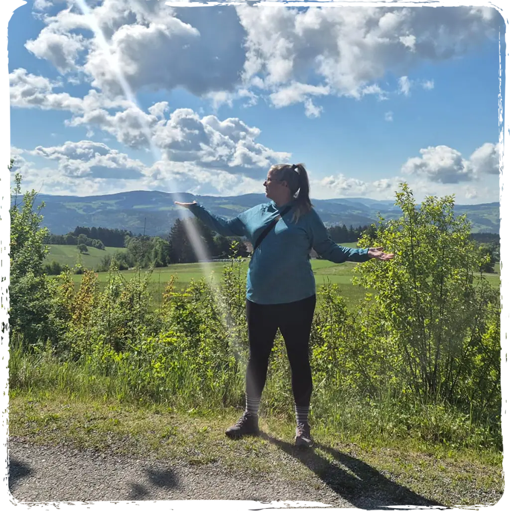 Raphaela steht mit geöffneten Armen in der Natur für Jenseitskontakte